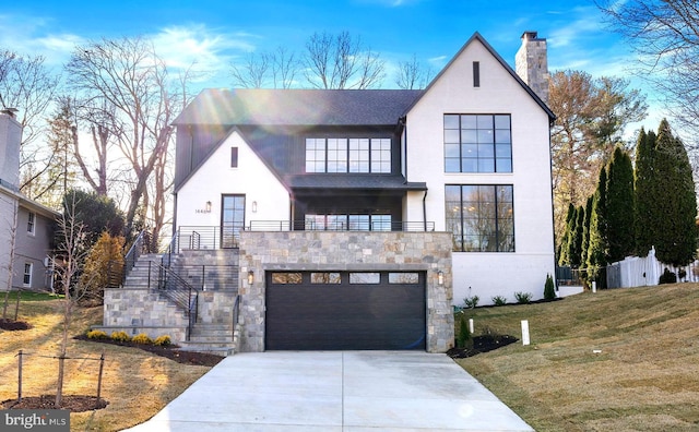 view of front of house featuring a chimney, concrete driveway, a front yard, a garage, and stone siding