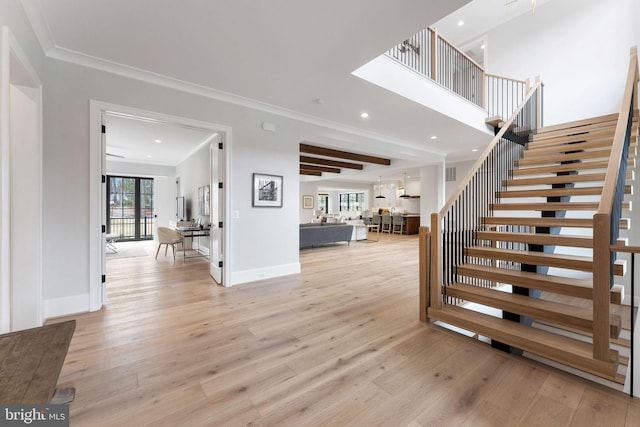 entryway featuring baseboards, ornamental molding, stairs, light wood-style floors, and recessed lighting