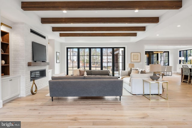 living room with light wood-type flooring, a fireplace, beam ceiling, and recessed lighting