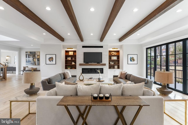 living room with recessed lighting, a fireplace, built in features, light wood-style floors, and beamed ceiling