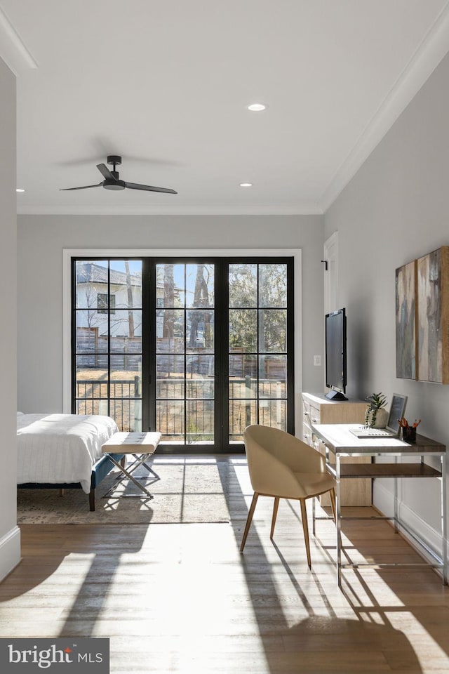 interior space with access to outside, ornamental molding, multiple windows, and wood finished floors