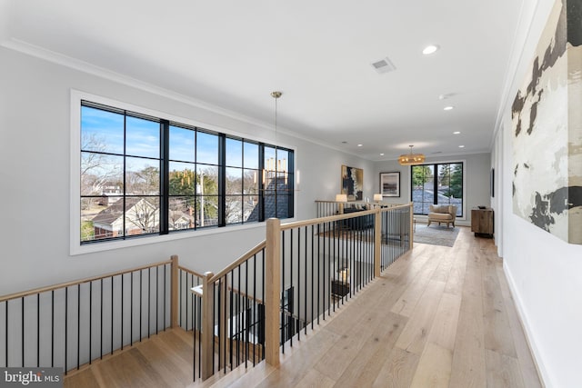 corridor featuring recessed lighting, an upstairs landing, baseboards, ornamental molding, and light wood finished floors