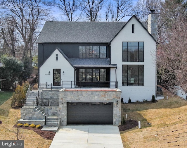 view of front of property with concrete driveway, a chimney, stairway, roof with shingles, and an attached garage