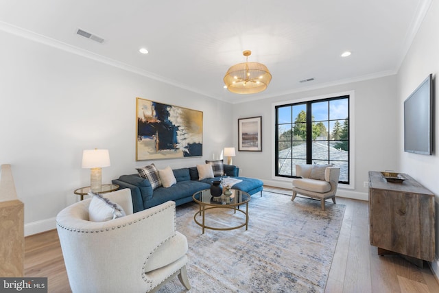 living area with visible vents, crown molding, and wood finished floors