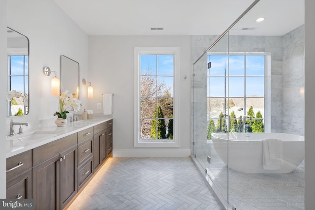 bathroom featuring a sink, double vanity, and a wealth of natural light