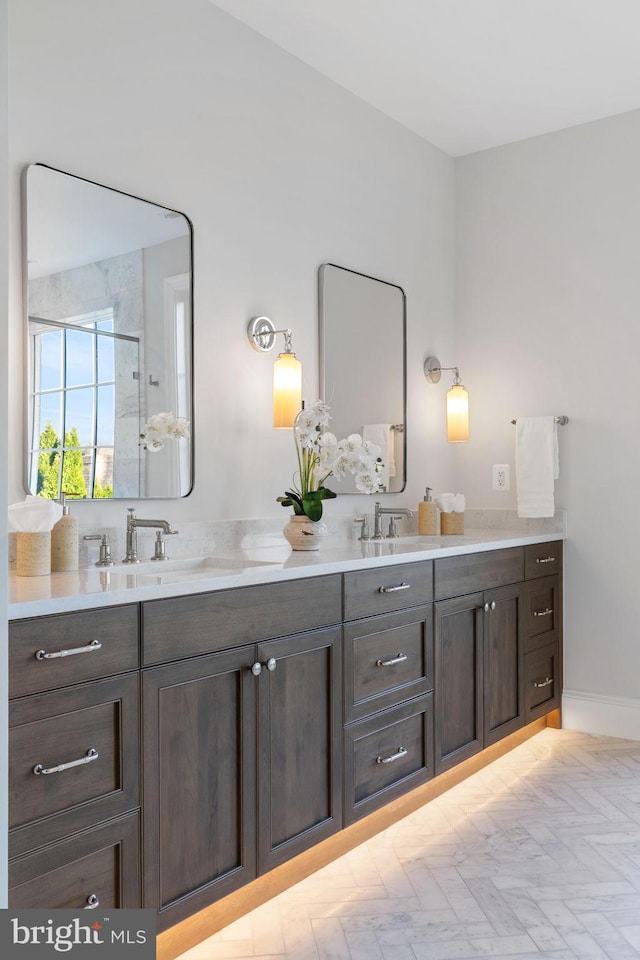 full bathroom featuring double vanity, a sink, and baseboards