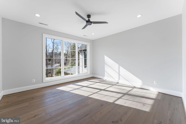 empty room featuring baseboards, wood-type flooring, visible vents, and recessed lighting