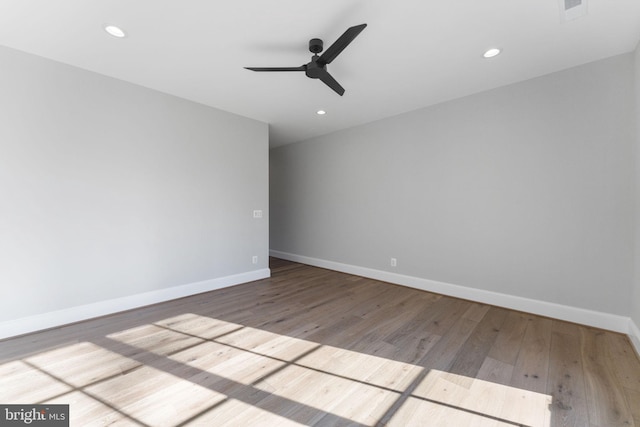 spare room with recessed lighting, wood finished floors, and baseboards