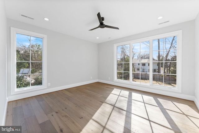 spare room featuring baseboards, visible vents, and hardwood / wood-style floors