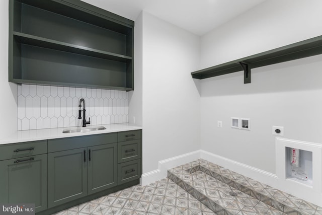 washroom featuring hookup for a washing machine, a sink, baseboards, cabinet space, and electric dryer hookup