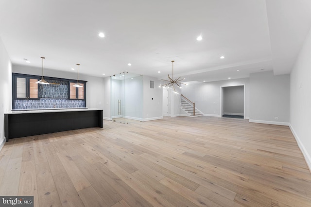 unfurnished living room with baseboards, stairway, light wood-type flooring, and recessed lighting