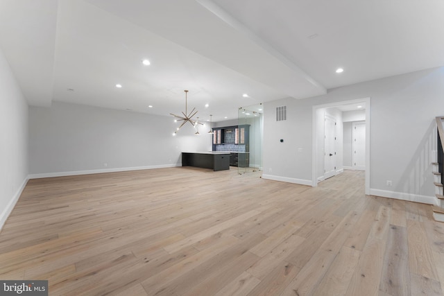 unfurnished living room with stairway, light wood-type flooring, visible vents, and baseboards