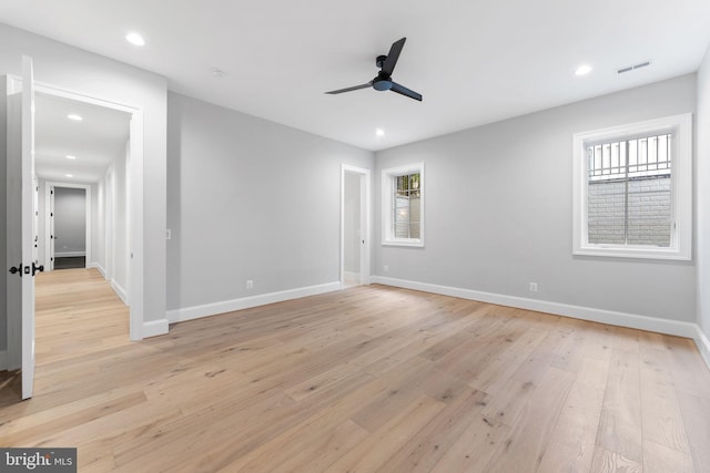 unfurnished room with light wood-type flooring, baseboards, visible vents, and recessed lighting