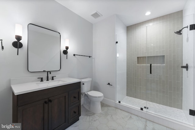 full bathroom featuring toilet, vanity, visible vents, baseboards, and a stall shower