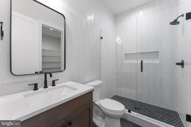 full bathroom featuring toilet, a shower stall, tile walls, and vanity