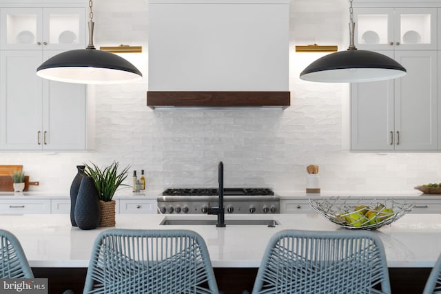 kitchen featuring wall chimney exhaust hood, backsplash, and light countertops