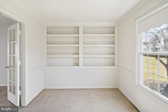 interior space featuring built in features, carpet floors, and crown molding