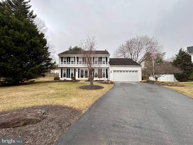 view of front of home featuring a front lawn, driveway, a porch, an attached garage, and a balcony