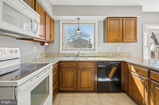 kitchen featuring white appliances, light tile patterned floors, light stone countertops, a sink, and brown cabinets