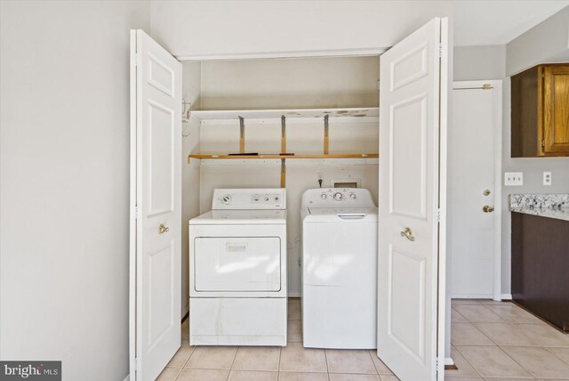 laundry room featuring washing machine and clothes dryer, laundry area, and light tile patterned floors