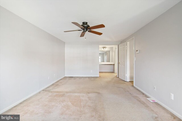 carpeted empty room featuring baseboards and ceiling fan