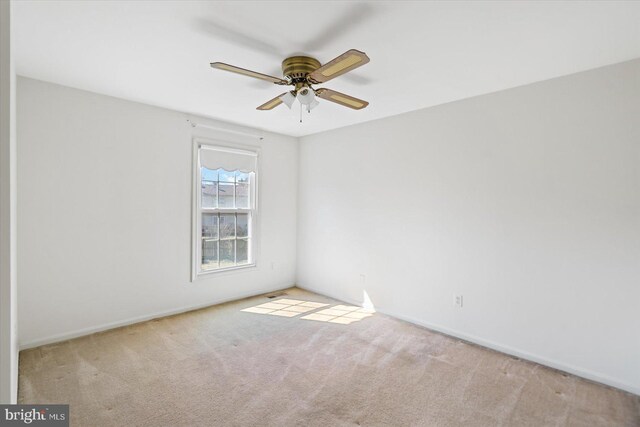 unfurnished room featuring a ceiling fan, carpet, and baseboards