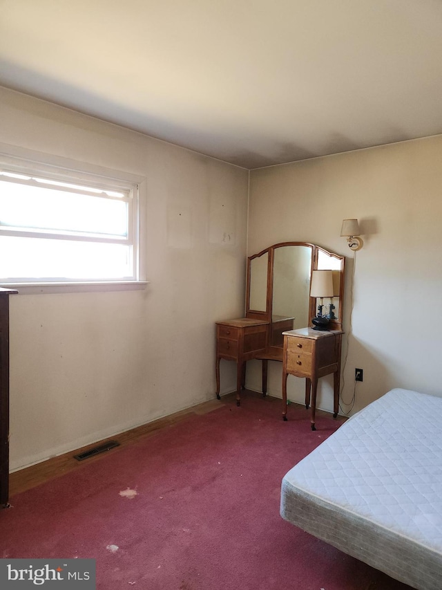 bedroom with visible vents and carpet