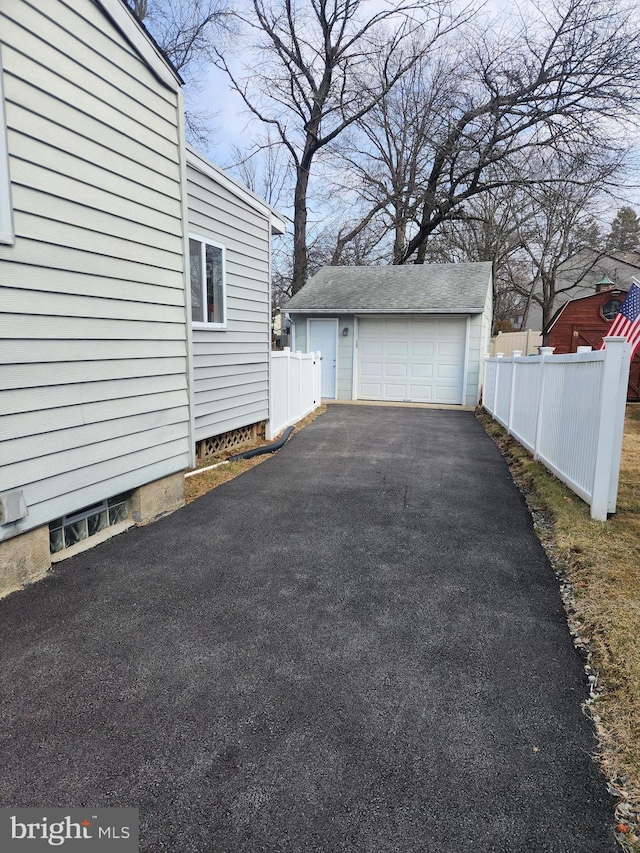 detached garage with driveway and fence