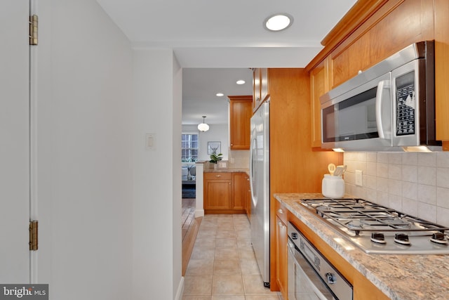 kitchen with brown cabinets, backsplash, recessed lighting, stainless steel appliances, and light tile patterned floors