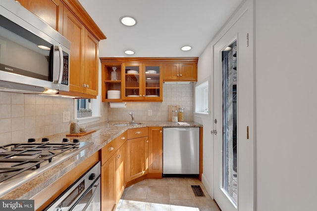 kitchen with visible vents, a sink, tasteful backsplash, stainless steel appliances, and light tile patterned flooring