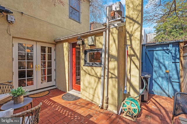 entrance to property featuring a patio area, stucco siding, and french doors