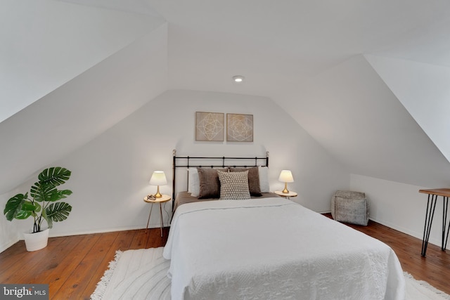 bedroom featuring vaulted ceiling, baseboards, and wood-type flooring