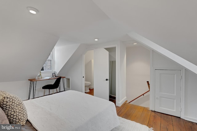 bedroom with recessed lighting, connected bathroom, lofted ceiling, and hardwood / wood-style floors