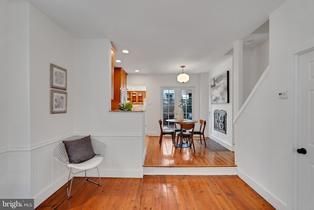 interior space featuring recessed lighting, a wainscoted wall, light wood-style flooring, and a decorative wall