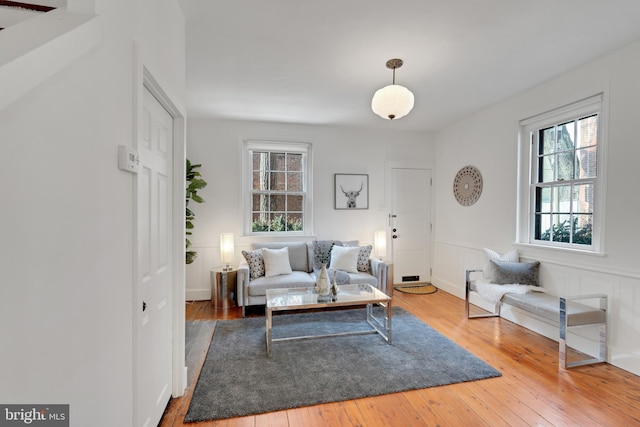 living room featuring a wainscoted wall and hardwood / wood-style floors