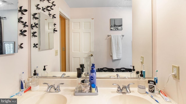 bathroom with double vanity, visible vents, and a sink