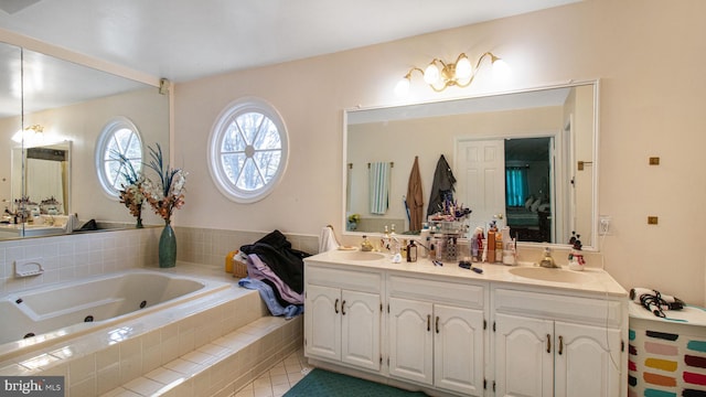 full bathroom featuring double vanity, a whirlpool tub, tile patterned flooring, and a sink