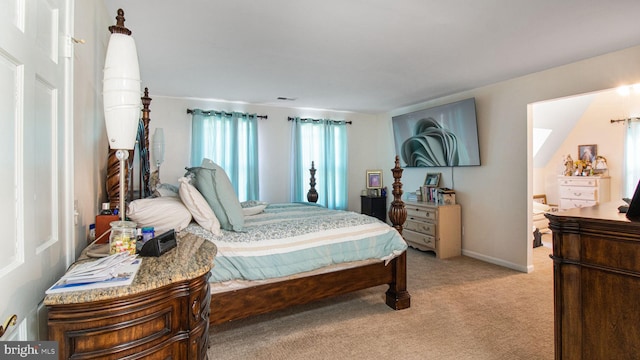 bedroom with light colored carpet and baseboards