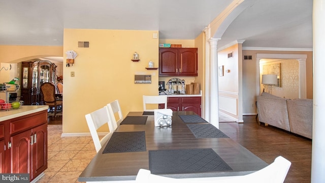 dining area with visible vents, ornamental molding, arched walkways, decorative columns, and baseboards