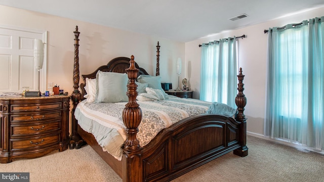 bedroom featuring baseboards, visible vents, and light carpet