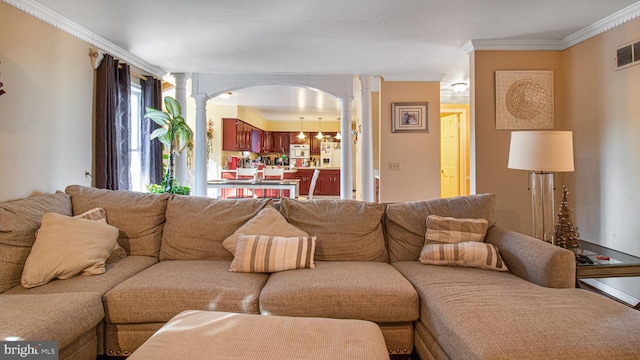 living area with crown molding, decorative columns, arched walkways, and visible vents