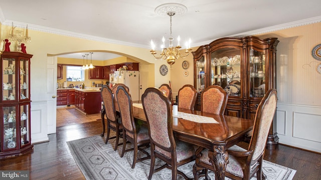 dining area featuring arched walkways, dark wood-style floors, and an inviting chandelier