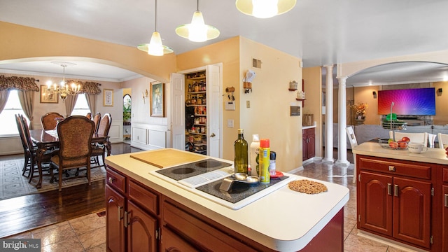 kitchen with visible vents, a wainscoted wall, decorative columns, light countertops, and pendant lighting