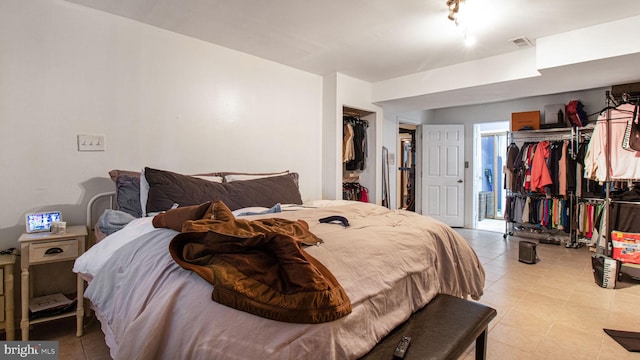 bedroom featuring a closet, visible vents, and a walk in closet