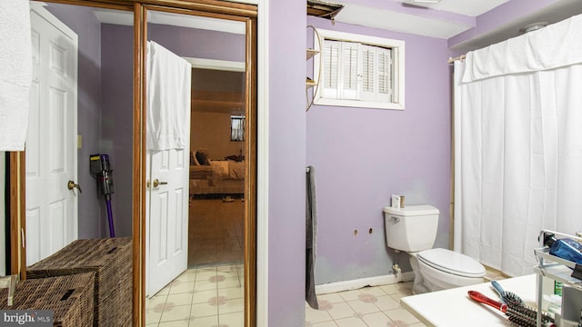 bathroom featuring toilet and baseboards