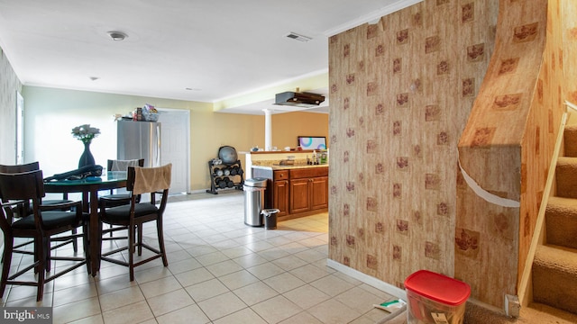 dining space featuring light tile patterned floors, visible vents, crown molding, and stairs