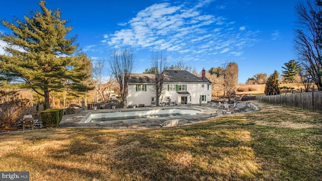 back of house with a patio, a fenced in pool, a yard, a fenced backyard, and a chimney