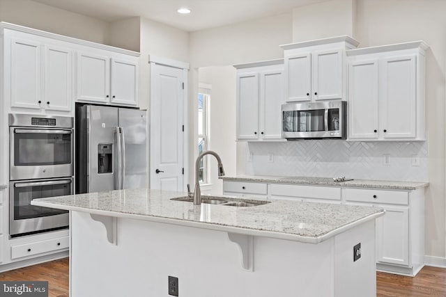 kitchen with stainless steel appliances, dark wood-type flooring, a sink, and white cabinets