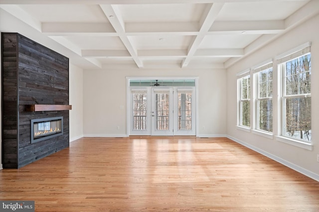 unfurnished living room with baseboards, a fireplace, and light wood finished floors