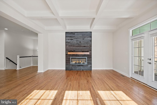 unfurnished living room with baseboards, coffered ceiling, and wood finished floors